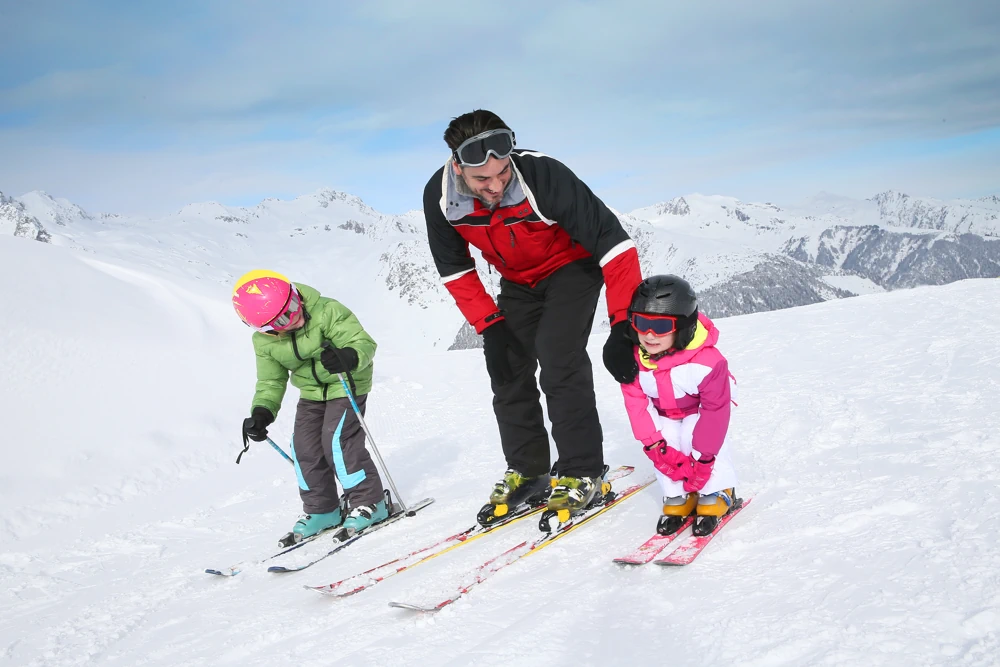 Father teaching his kids how to ski