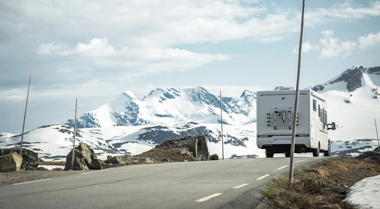 Caravan on the road with snowy mountains
